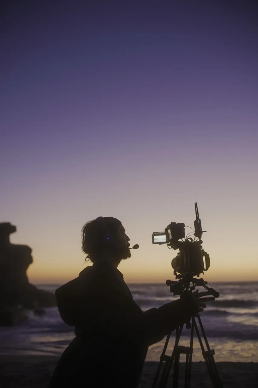 Silueta de Daniel Blanco con cámara al atardecer frente al mar